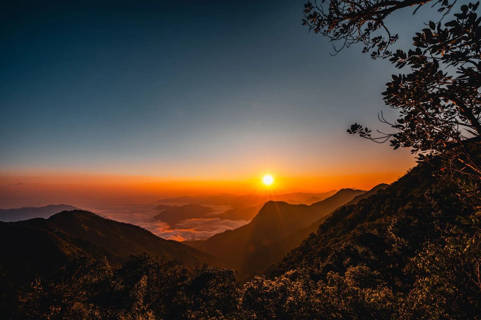 Lever de soleil vu d'un sommet volcanique, mer de nuages entre les crêtes, comme au sommet du mont Agung à Bali