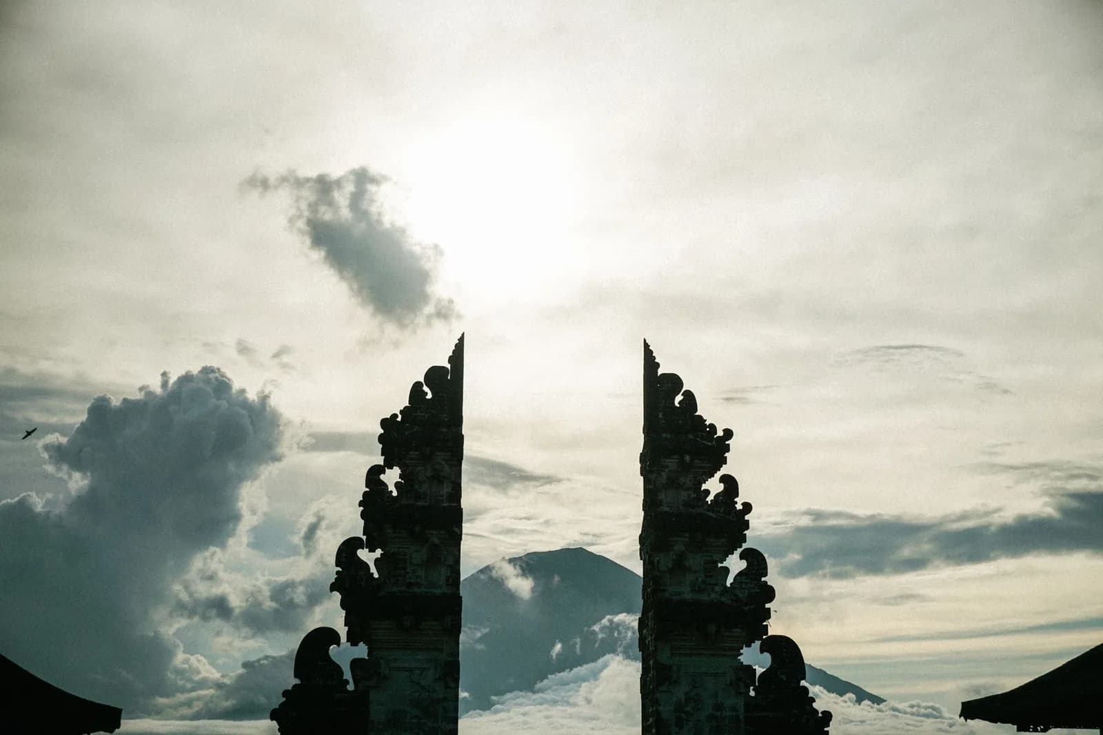 Portes fendues du temple de Lempuyang à contre-jour, avec la silhouette du mont Agung visible entre les deux battants, Bali