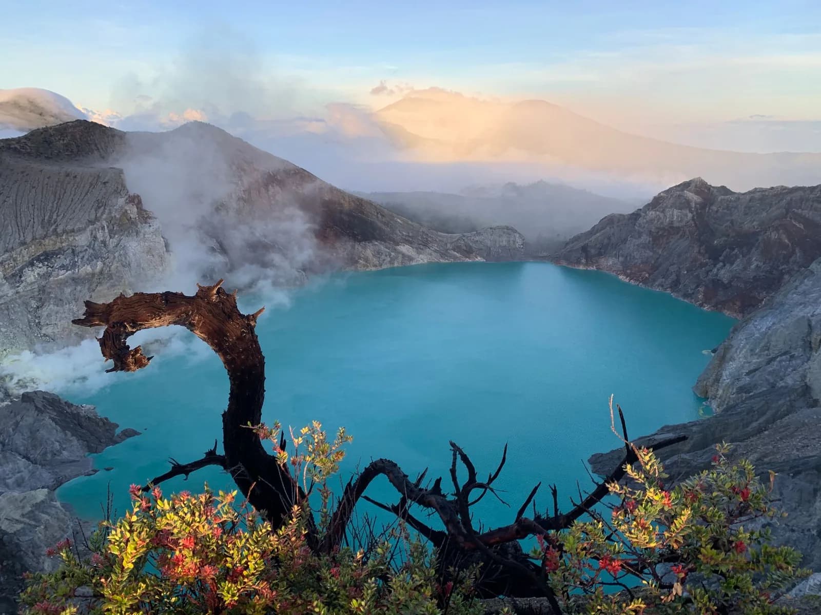 Le lac acide turquoise du cratère de l'Ijen au petit matin, entouré de parois de soufre et de fumées, Java Est