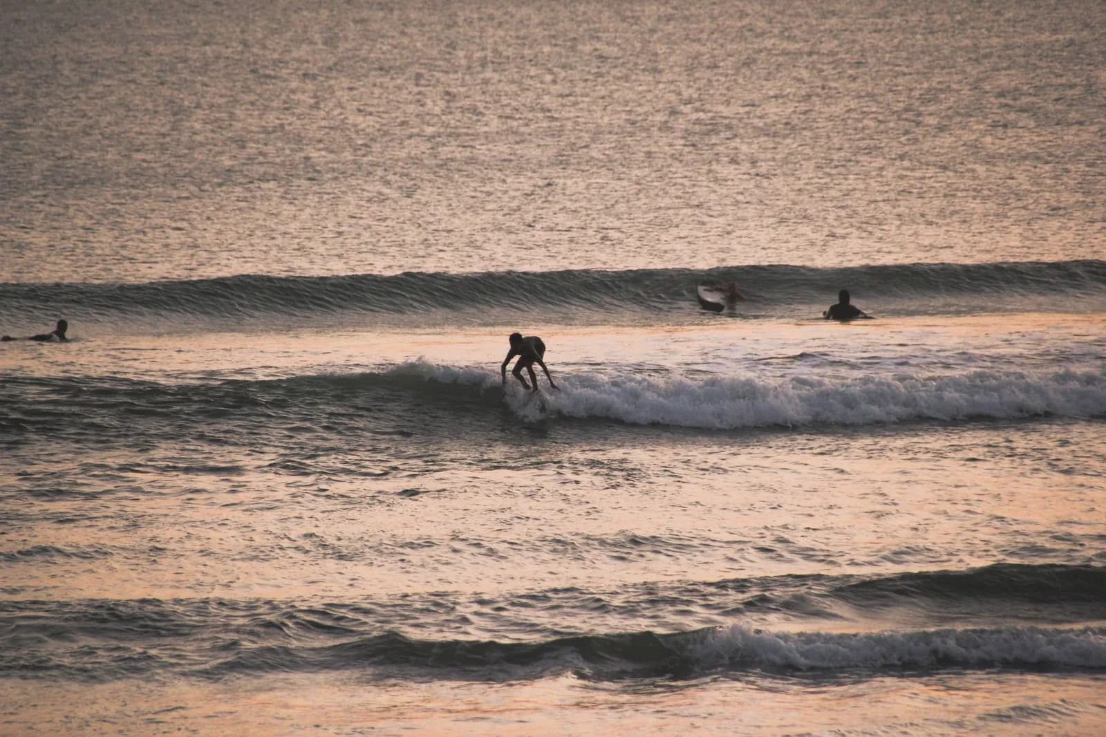 Surfeurs à l'eau sur un beach break de la côte ouest de Bali en fin de journée, comme devant Batu Bolong à Canggu