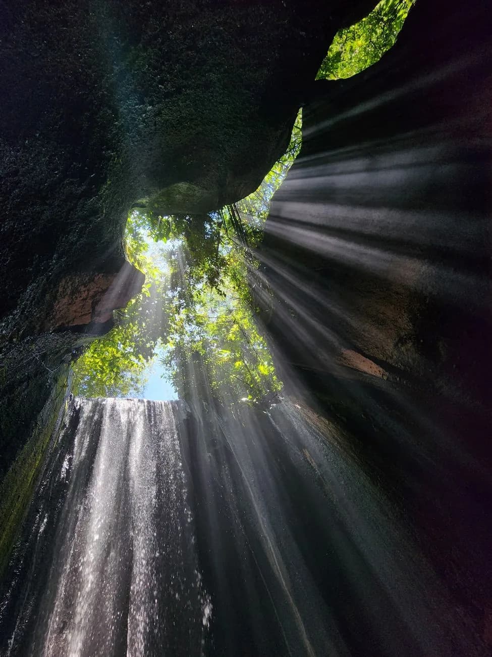 Rayons de soleil traversant la gorge de la cascade de Tukad Cepung près d'Ubud à Bali
