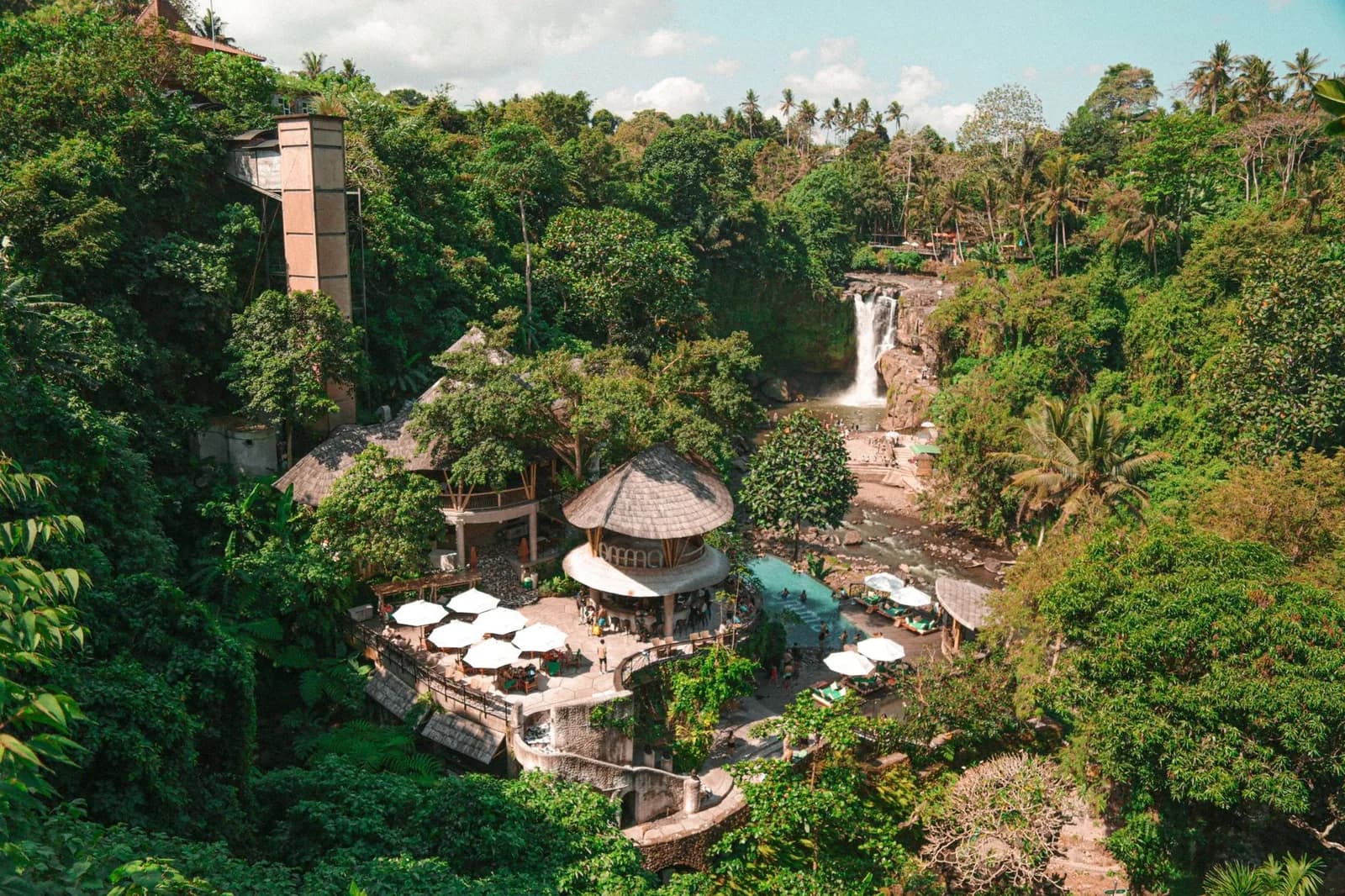Hôtel dans la jungle près d'Ubud, terrasse sous les arbres et cascade en arrière-plan
