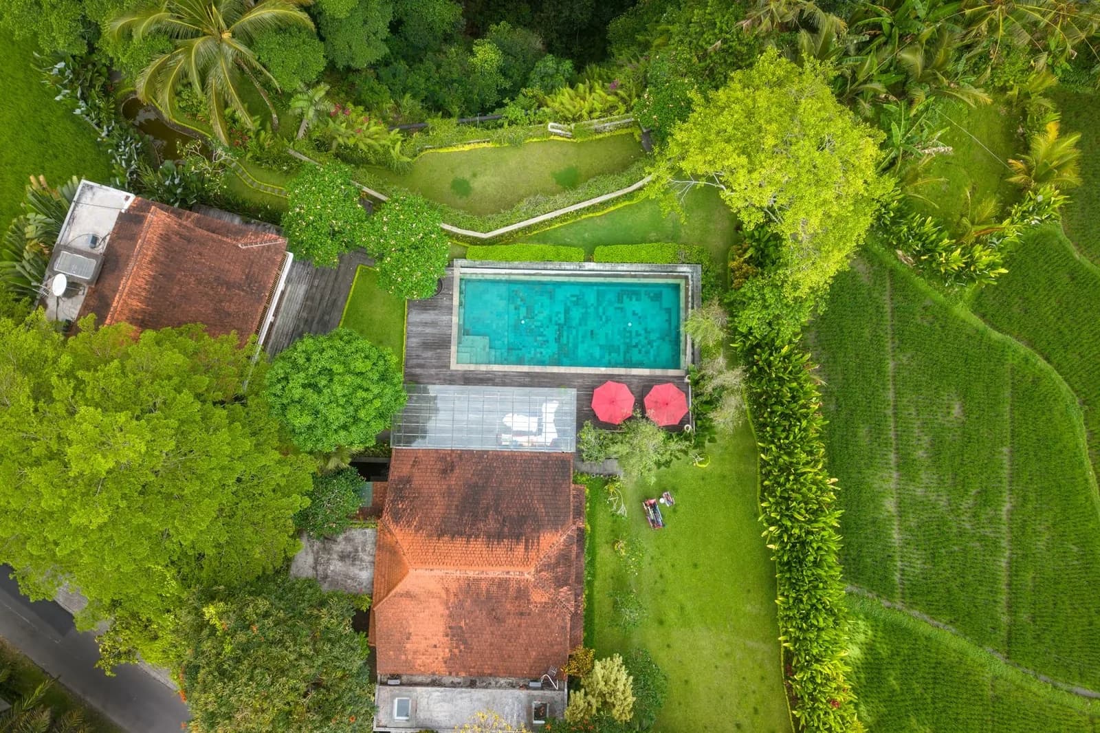 Vue aérienne d'une villa avec piscine entourée de jardins et de rizières près de Canggu