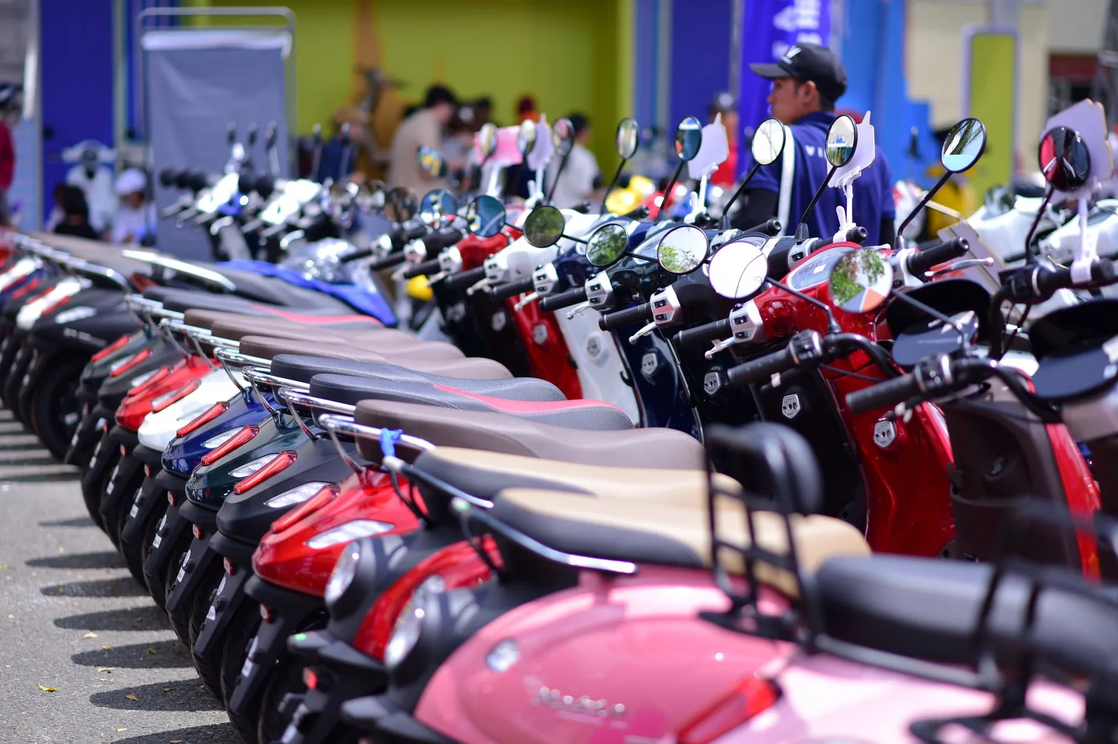 Rangée de scooters automatiques neufs alignés devant une agence, la flotte type d'un loueur de deux-roues en Asie du Sud-Est