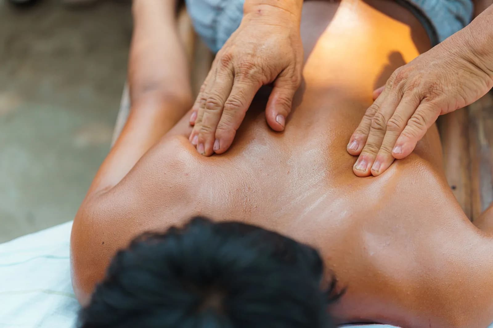 Massage balinais du dos à l'huile dans un pavillon ouvert, comme dans les spas de rue de Seminyak