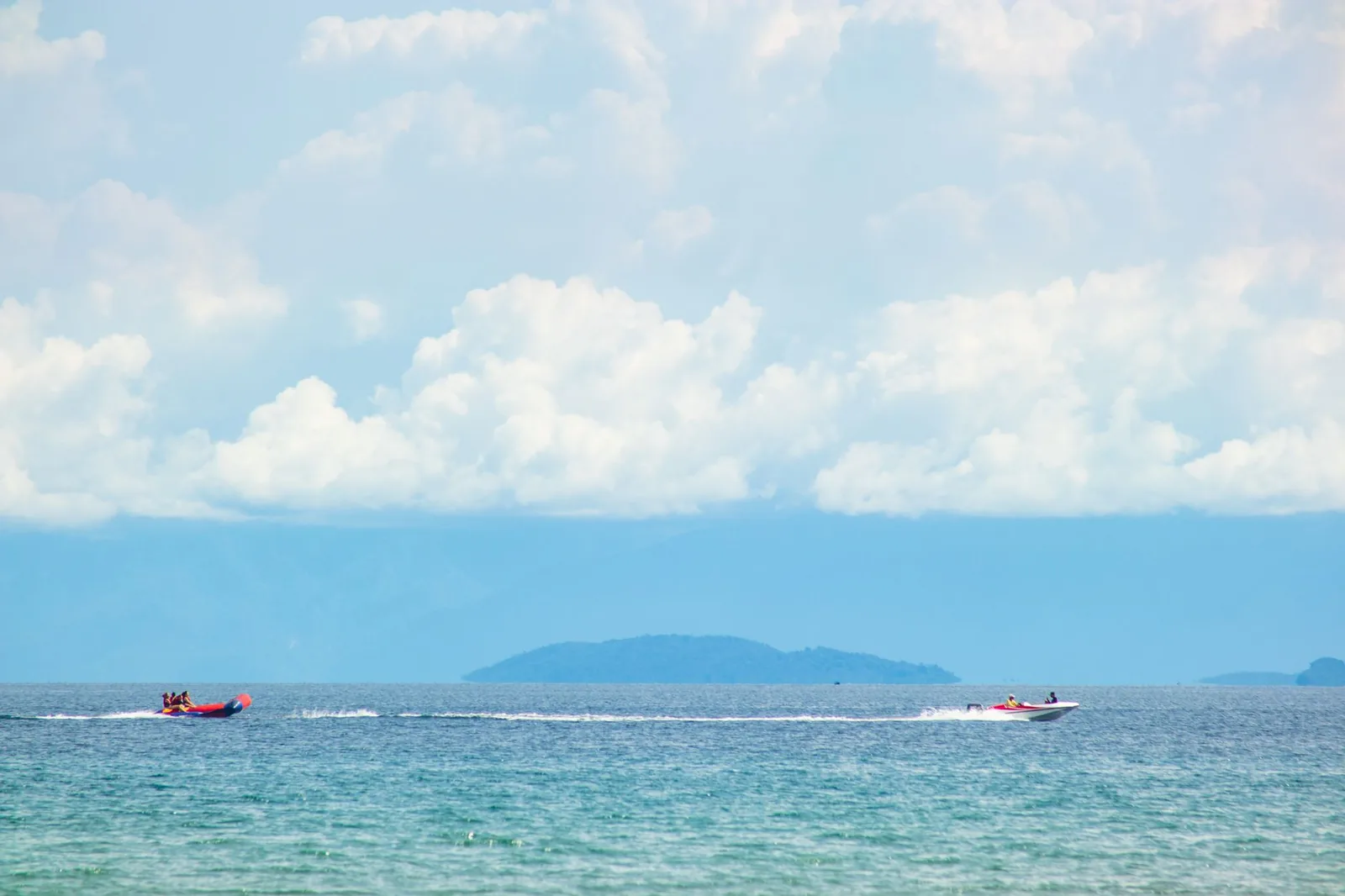 Banana boat tracté par un hors-bord sur une mer calme, sports nautiques de Tanjung Benoa au nord de Nusa Dua à Bali