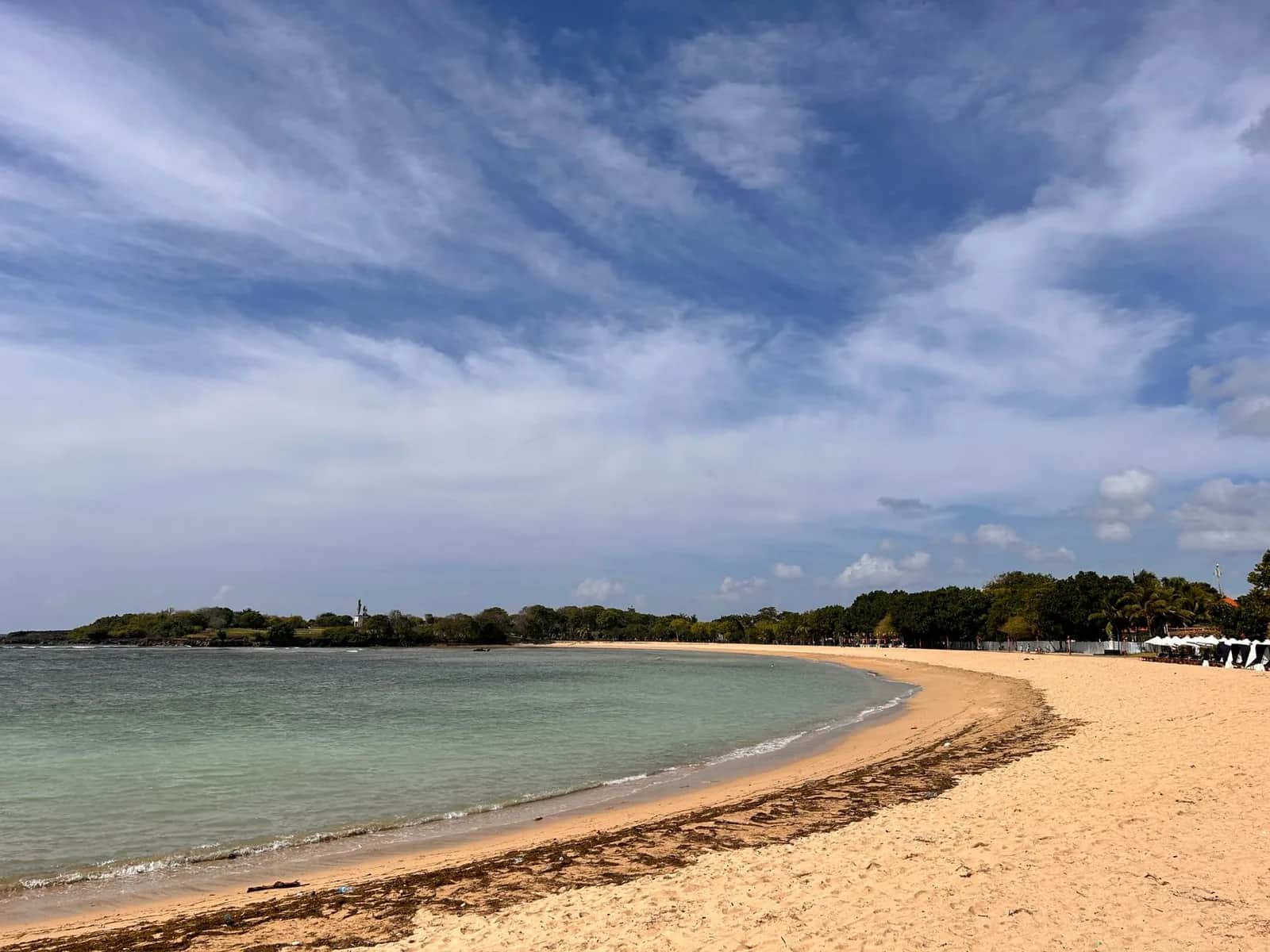 Plage de Nusa Dua au sud de Bali, sable clair en arc de cercle et lagon turquoise protégé par le récif