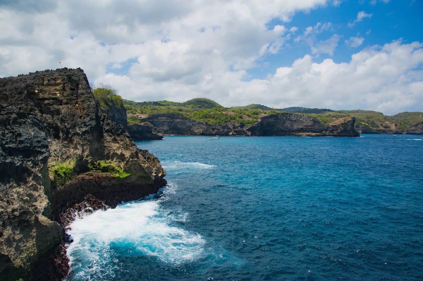 Falaise rongée par l'érosion et ressac au pied de la roche sur la côte de Nusa Penida, Bali
