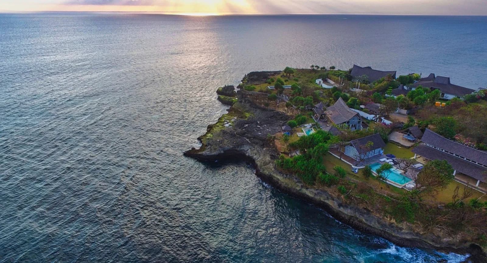 Villas avec piscine perchées sur une falaise face à l'océan au coucher du soleil, près de Nusa Penida