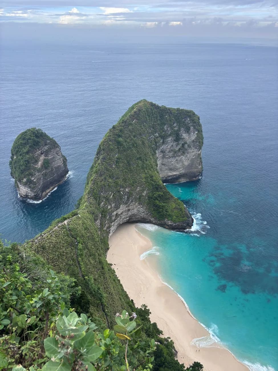 La plage de sable blanc de Kelingking et le shore break vus depuis le sentier de descente, à Nusa Penida