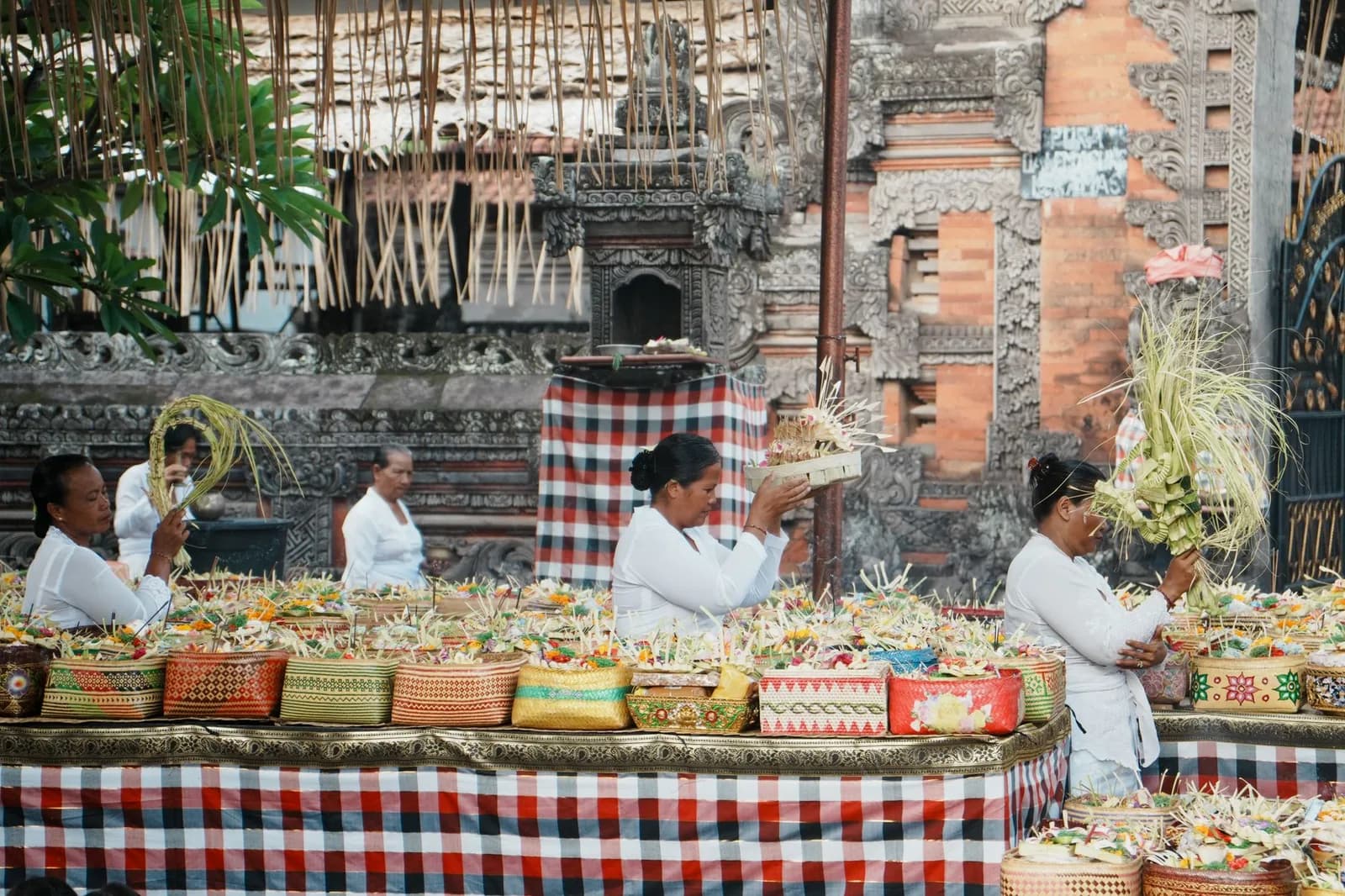 Femmes balinaises en tenue de cérémonie disposant des offrandes devant un temple hindou de Bali