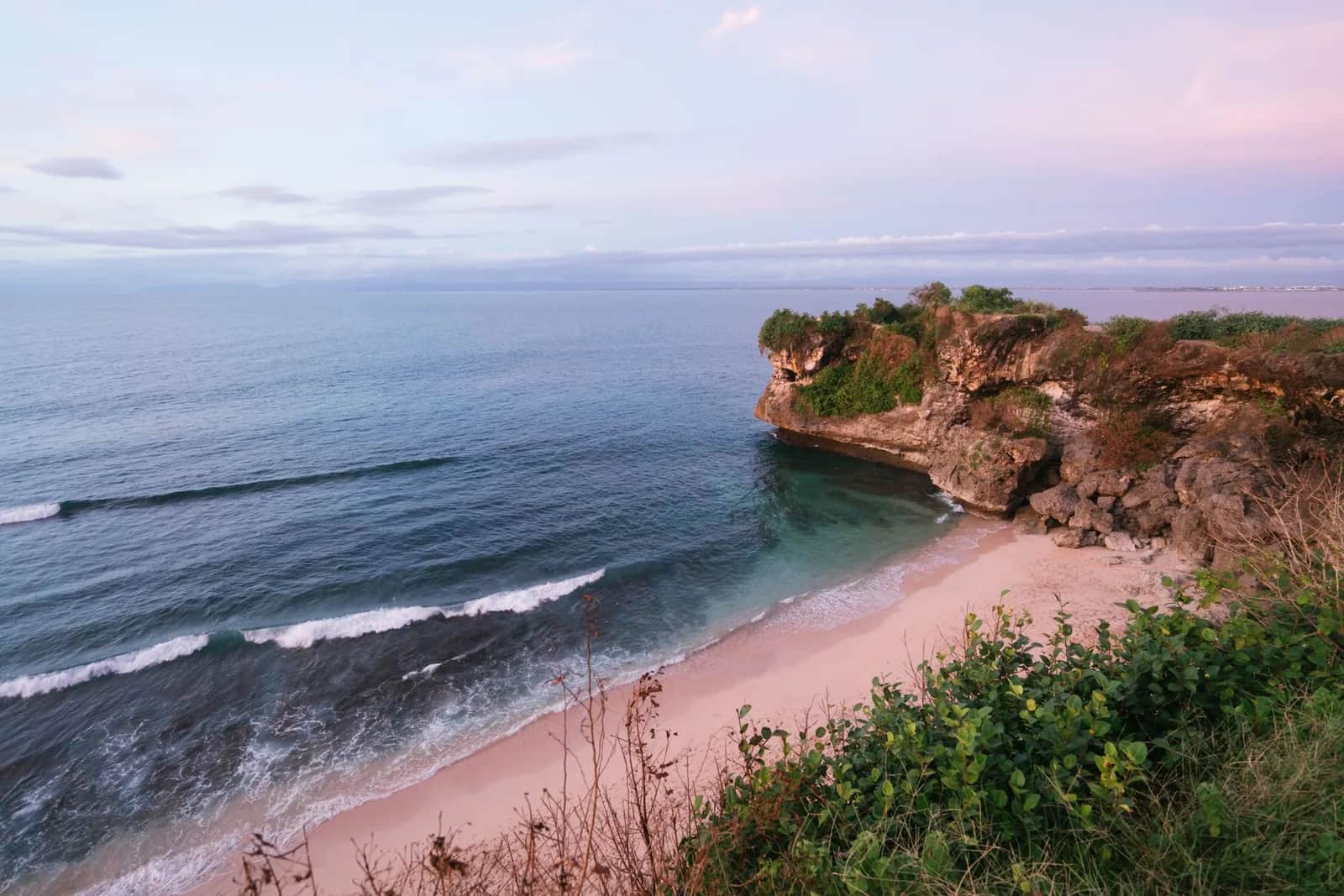 Plage de sable clair au pied des falaises de la péninsule du Bukit, au sud de Bali