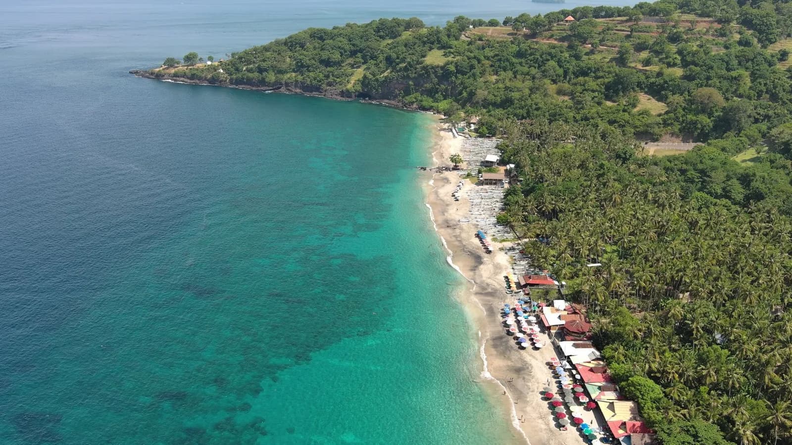Vue aérienne de Virgin Beach à Karangasem, dans l'est de Bali : baie turquoise, cocotiers et warungs