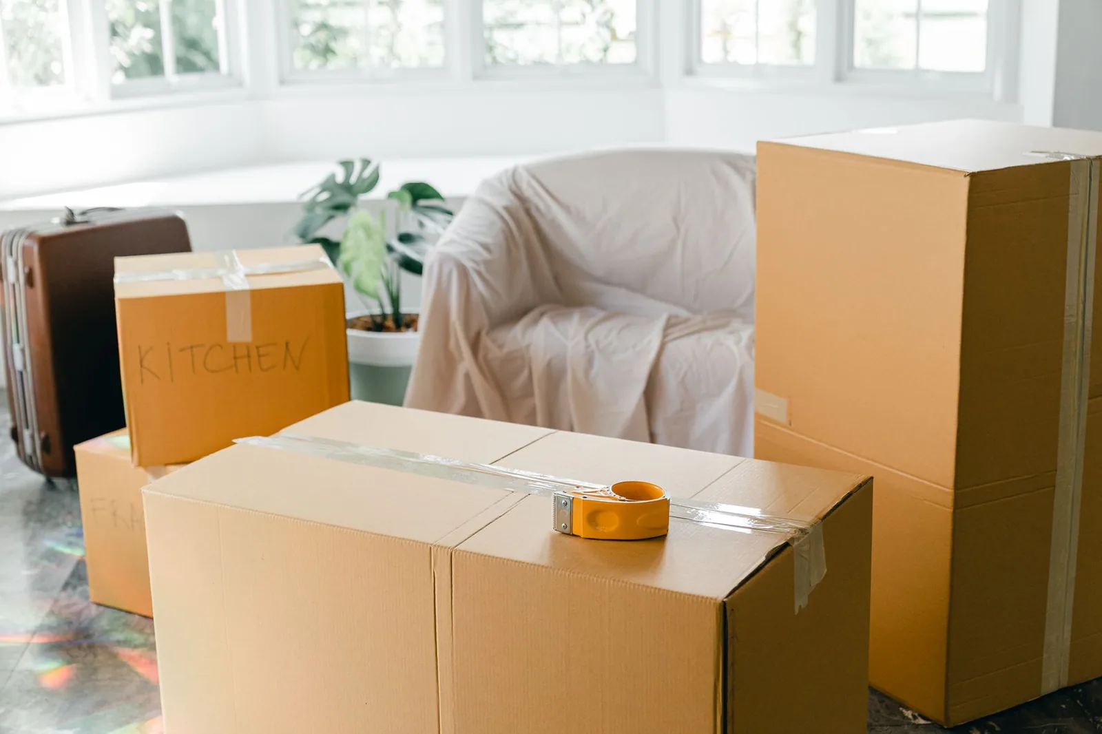 Cartons de déménagement étiquetés et valise prêts pour un départ en expatriation à Bali