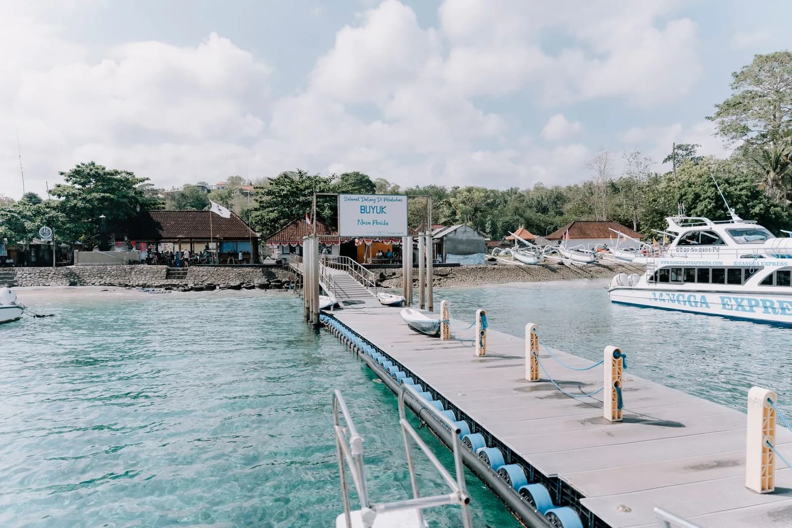 Ponton flottant du port de Buyuk à Nusa Penida, bateau rapide à quai et eau turquoise, à l'arrivée de la traversée depuis Sanur