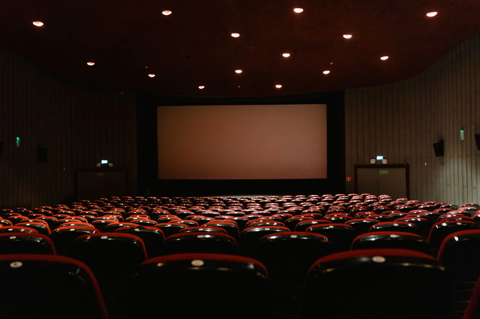 Salle de cinéma vide aux fauteuils rouges face à l'écran, comme au cinéma de Plaza Renon près de Sanur