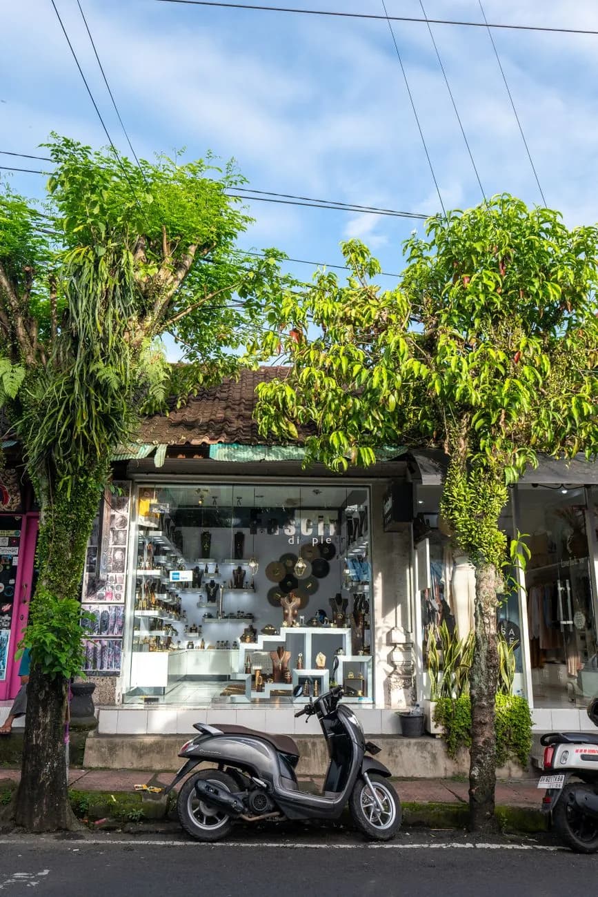 Devanture de boutique de créateur et scooter garé dans une rue commerçante de Seminyak, à Bali