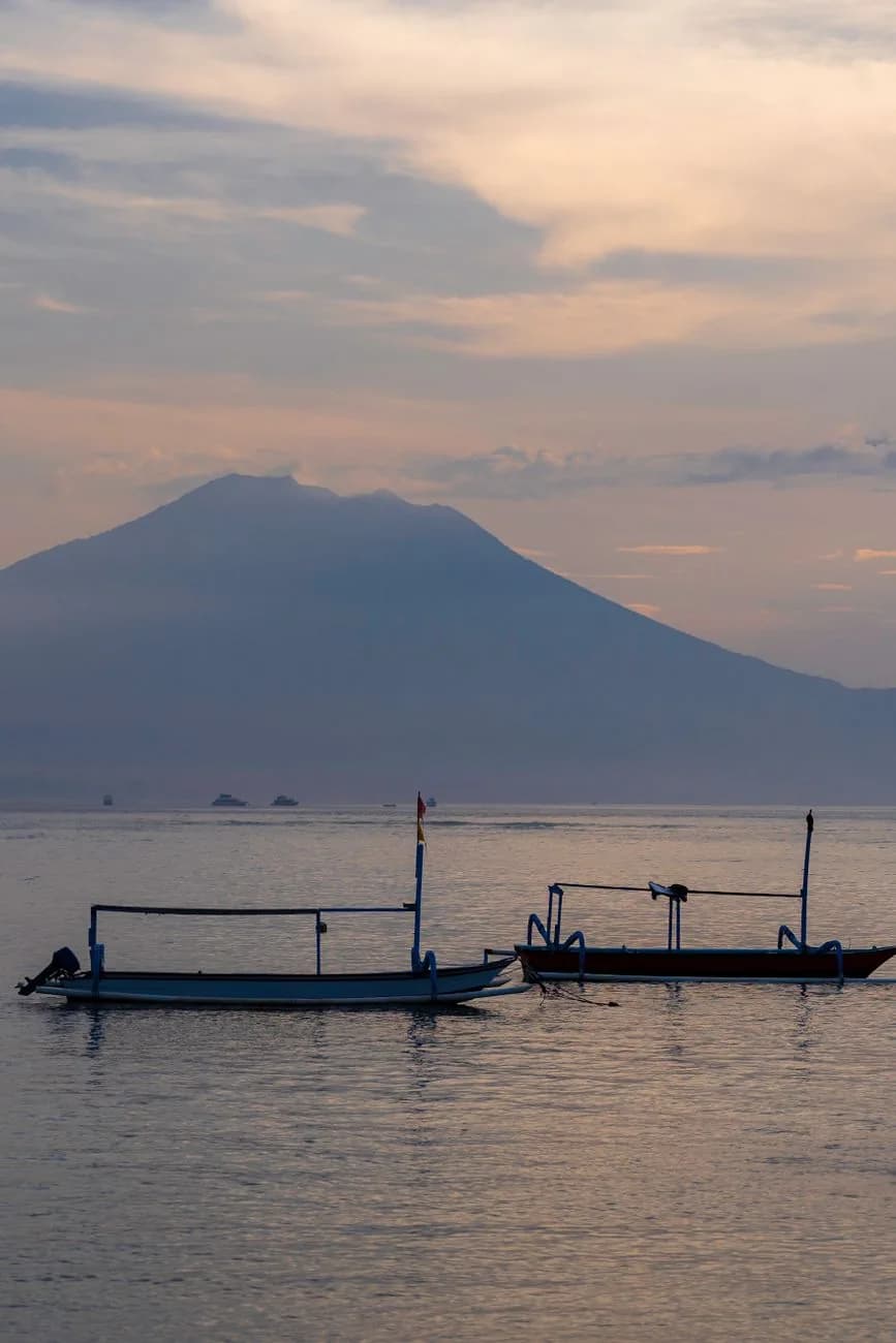 Bateaux de pêche traditionnels devant la silhouette du mont Agung au crépuscule, depuis Amed, est de Bali