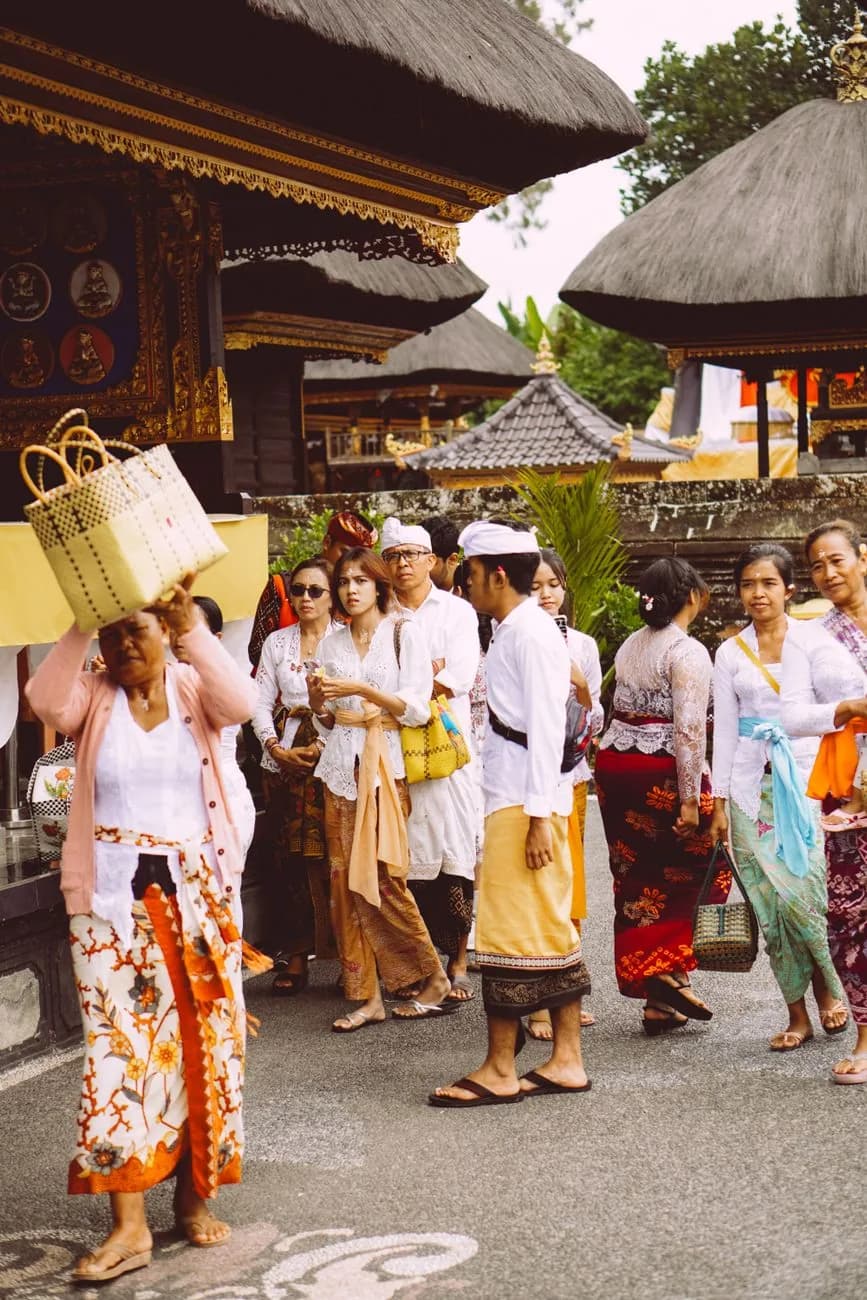 Fidèles balinais en sarong et tenue de cérémonie dans l'enceinte d'un temple de Bali