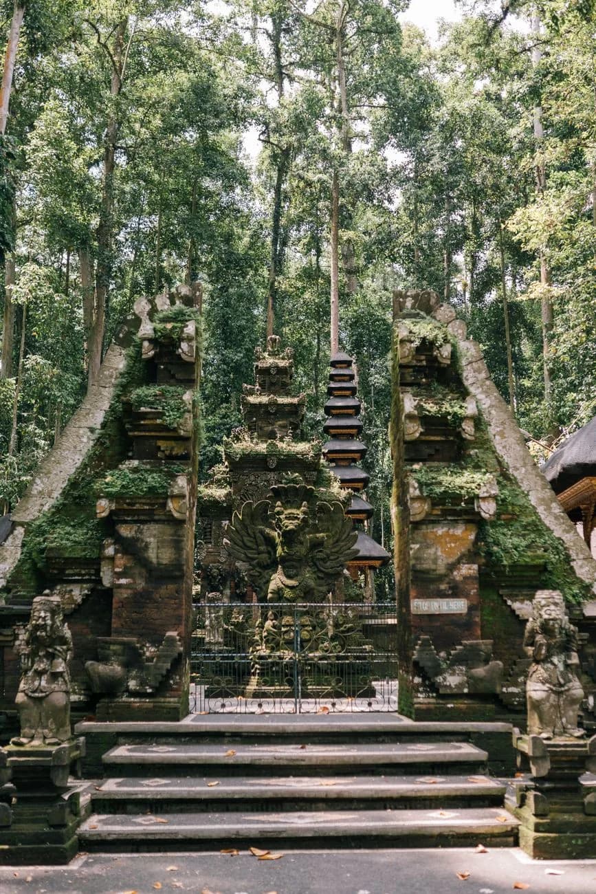 Porte de temple balinais et volées de marches de pierre montant dans la forêt, Bali