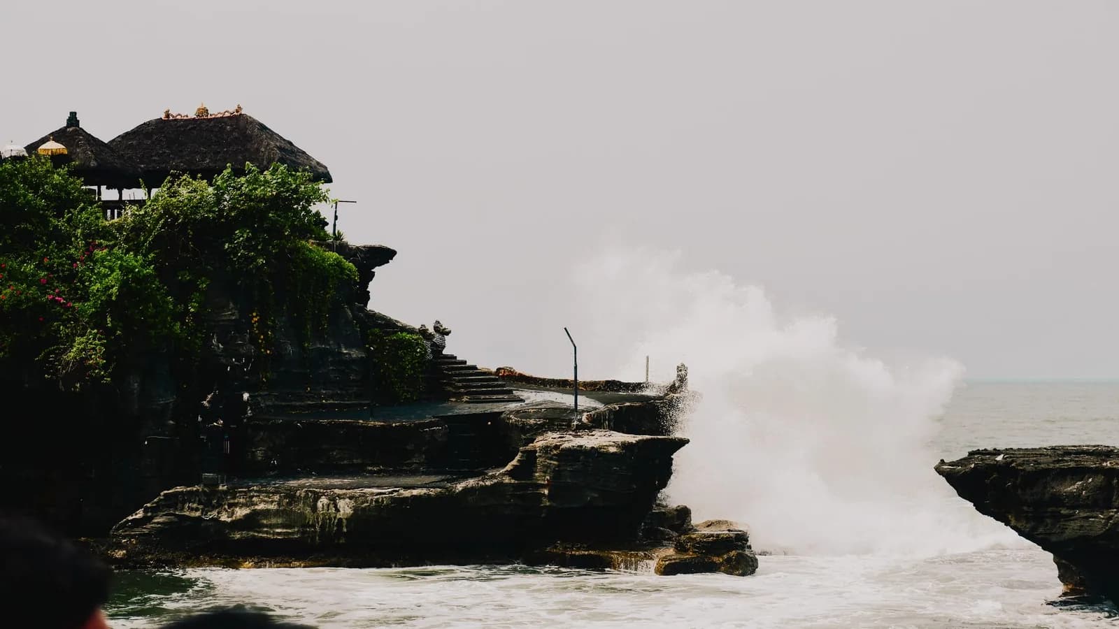 Grosse vague s'écrasant sur la base du rocher du temple de Tanah Lot, Bali