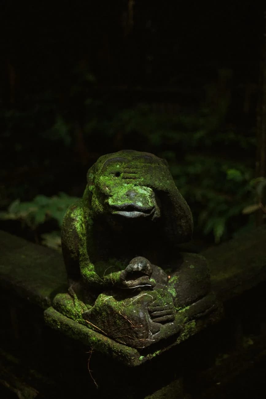Statue de pierre couverte de mousse représentant un singe, à l'entrée d'un temple de la Monkey Forest d'Ubud à Bali