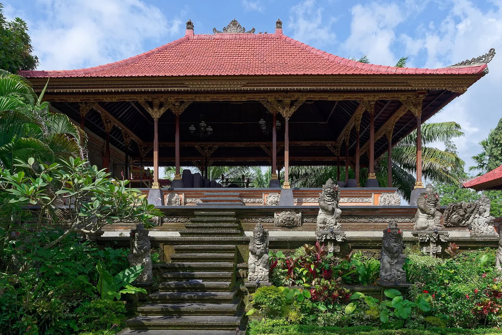 Pavillon au toit de tuiles rouges et statues dans la cour du palais d'Ubud (Puri Saren Agung), Bali