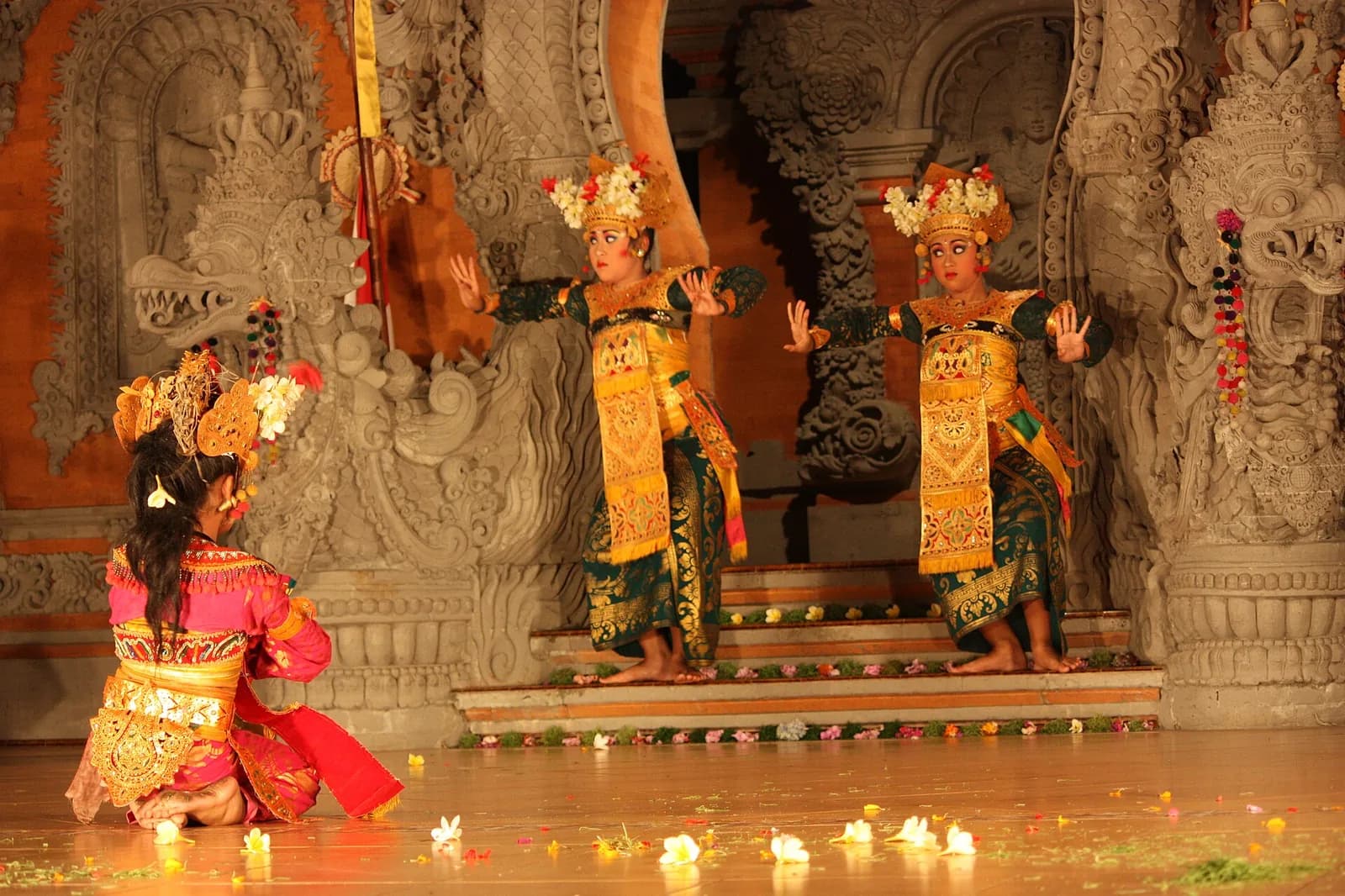 Danseuses de Legong sur une scène éclairée en soirée à Ubud, Bali