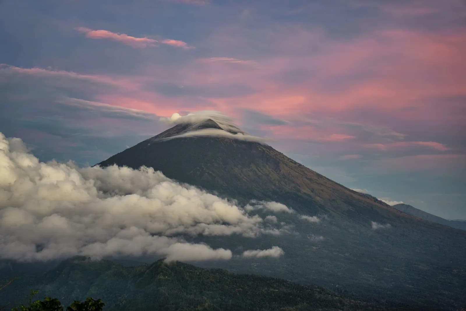 Le cône du mont Agung coiffé d'un nuage lenticulaire dans la lumière rose du crépuscule, est de Bali
