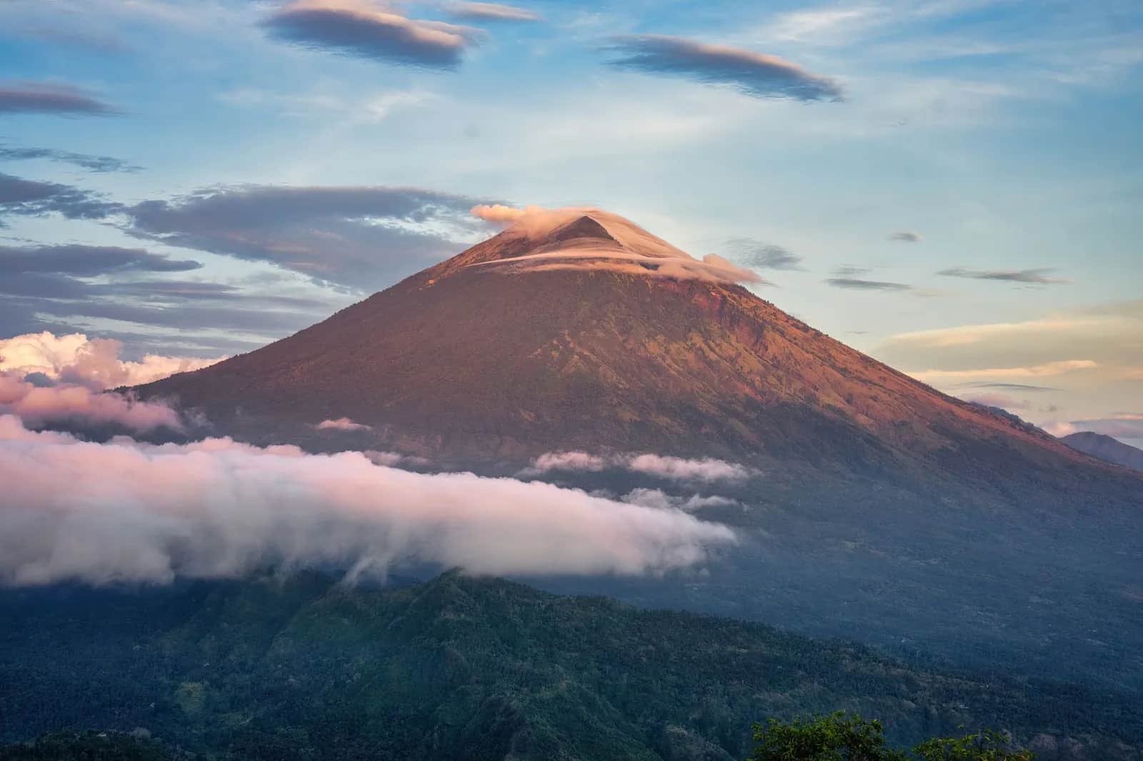 Le cône du mont Agung éclairé par le lever du soleil au-dessus d'une mer de nuages, est de Bali